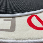Load image into Gallery viewer, Close-up of the sticky dots for additional safety found the underside of a children's round carpet with colorful letters of the alphabet arranged in a circular pattern

