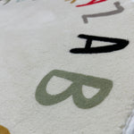 Load image into Gallery viewer, Close-up of the texture and the prints of letters A and B on a children's round carpet with colorful letters of the alphabet arranged in a circular pattern
