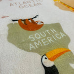Load image into Gallery viewer, Zoomed in illustrations of a sloth and bird on a children's carpet with world map and animal designs on a white background

